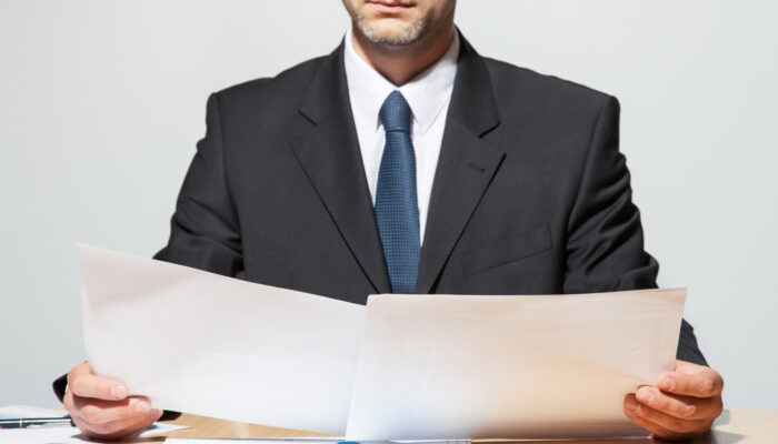Businessman,Comparing,Two,Documents,,Neutral,Background